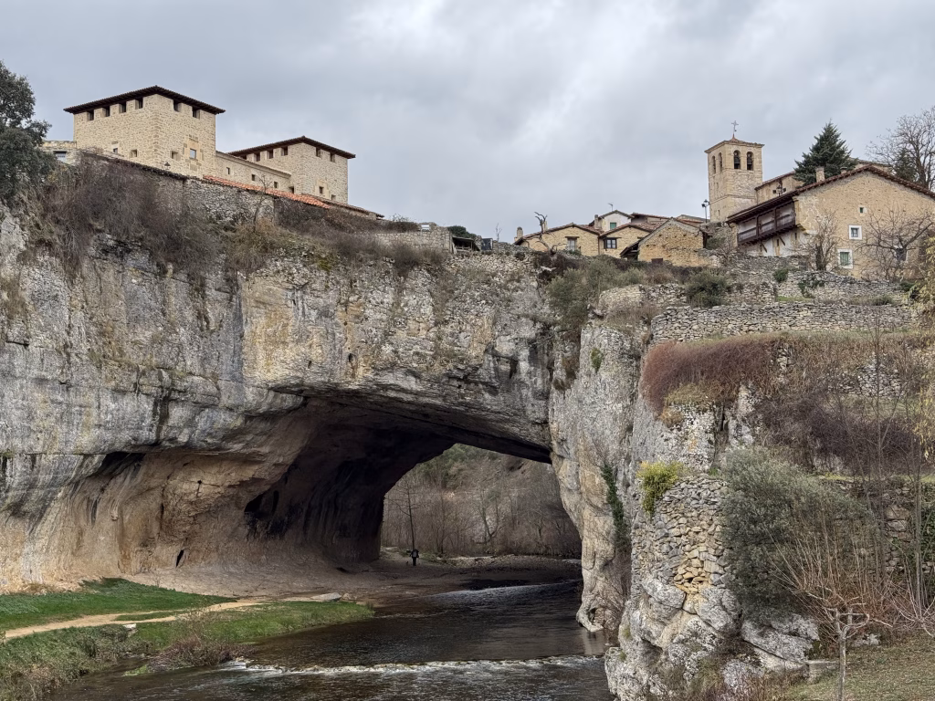 Mejor panorámica de Puentedey con el arco natural y las casas del pueblo vistas desde el puente frente al río Nela