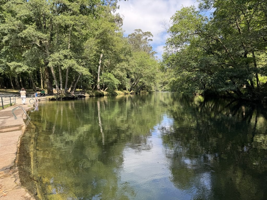 Zona de baño remansada en la playa fluvial de A Calzada, Ponte Caldelas, con aguas tranquilas y bandera azul