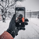 Usando el móvil para hacer fotos en un paisaje nevado de Andorra con conexión a internet